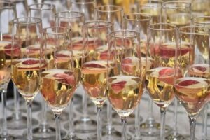 Group of glasses with champagne and strawberries at the buffet table at a party